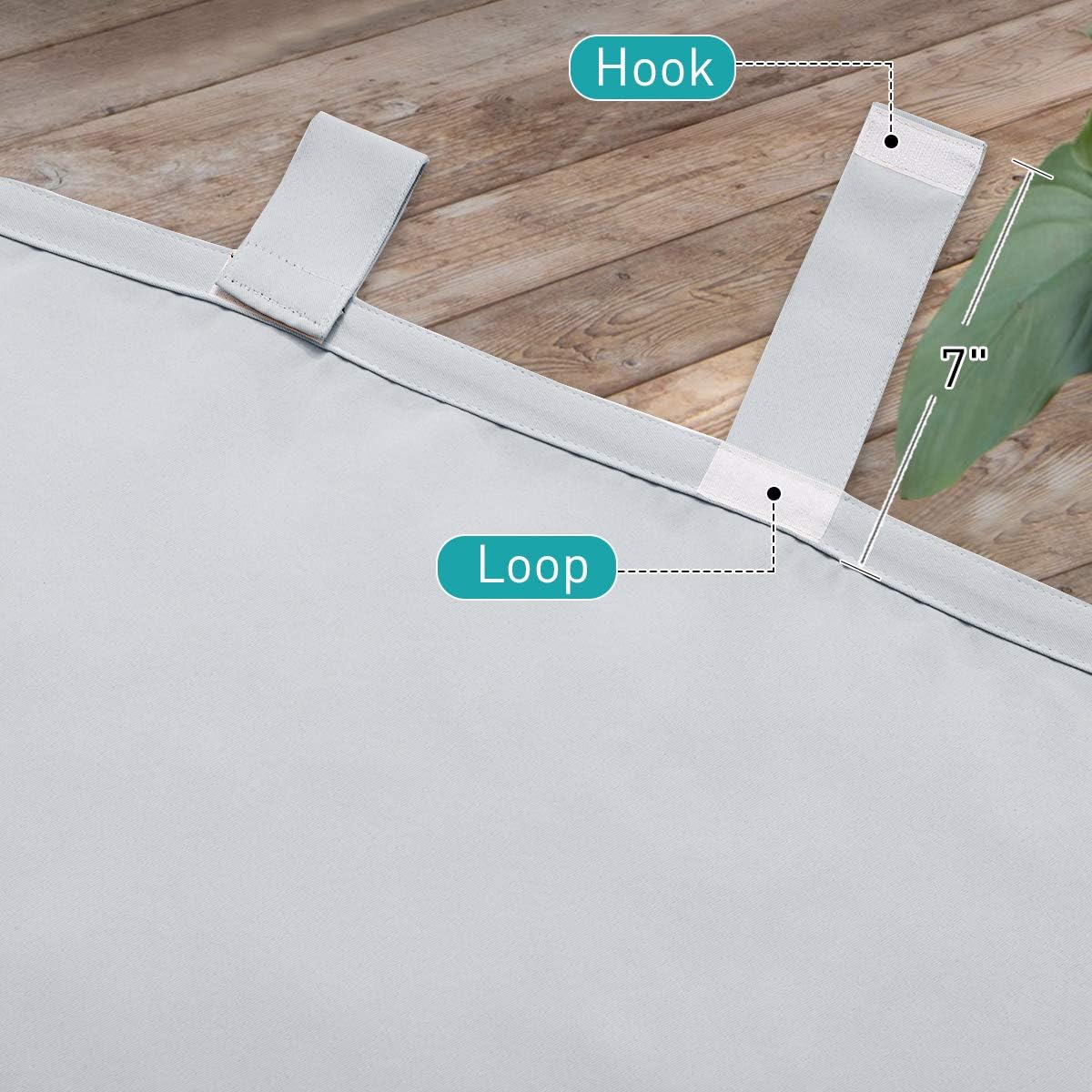 Close-up of light gray curtain panel with a 7-inch hook and loop tab top header for easy hanging.