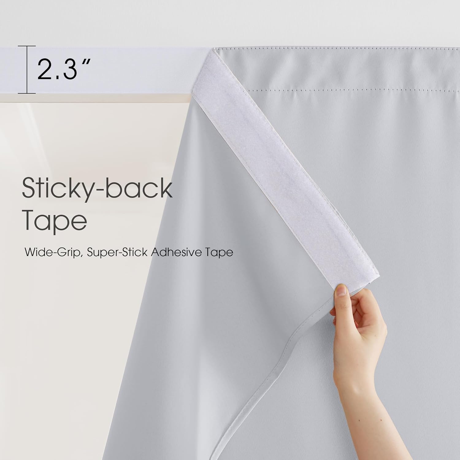 Hand demonstrating the 2.3-inch wide white sticky-back hook and loop tape on a light gray curtain.