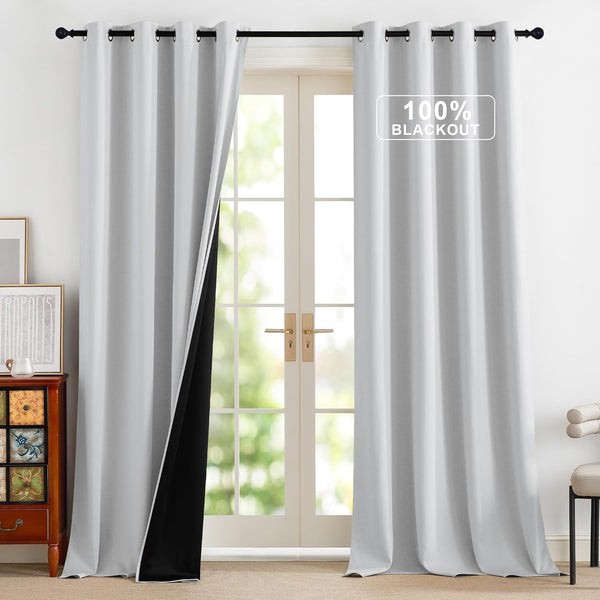 Pair of light gray grommet blackout curtains with visible black lining hanging over French doors.