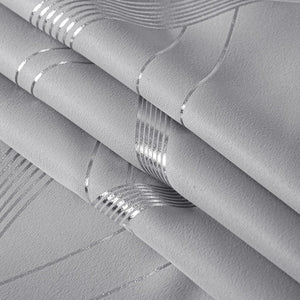 Detailed view of light gray textured wallpaper with shimmering metallic silver wavy and straight lines pattern.