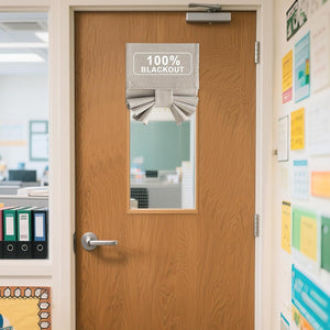 Light gray woven 100% blackout Roman shade with pleated bottom covering a door window.