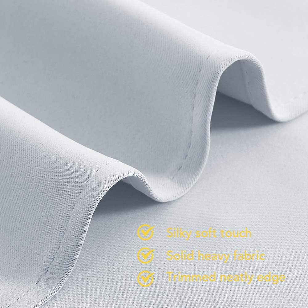 Close-up of soft, light gray fabric with elegant folds and a neatly trimmed edge. Highlights silky-smooth, heavy texture.