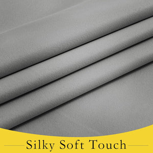 Silky light gray fabric draped in gentle folds, highlighting its smooth, flowing texture.