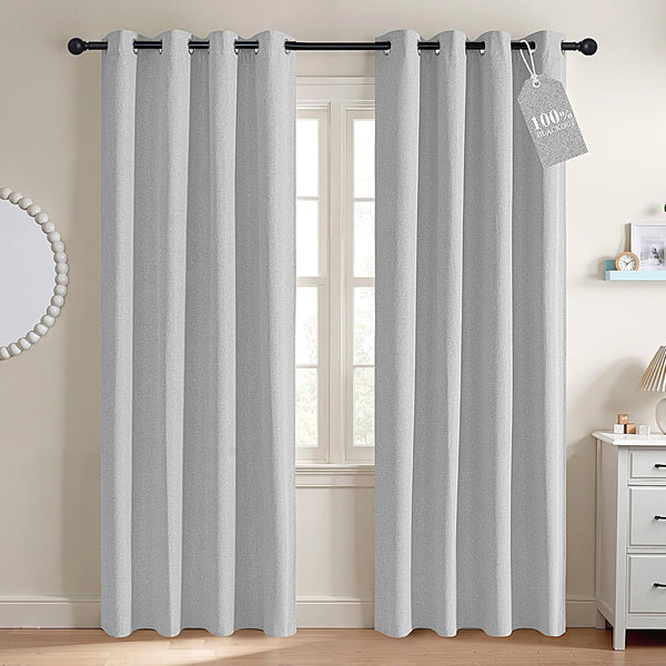 Light gray textured blackout grommet curtains on black rod, with '100% Blackout' tag visible.