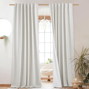 Light gray textured linen blend back tab curtains with white lining, on a wooden rod.