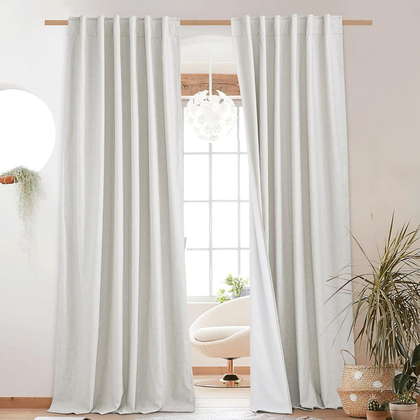 Light gray textured linen blend back tab curtains with white lining, on a wooden rod.