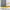 Light grey room darkening curtains with vertical folds beside a window and wicker chair.