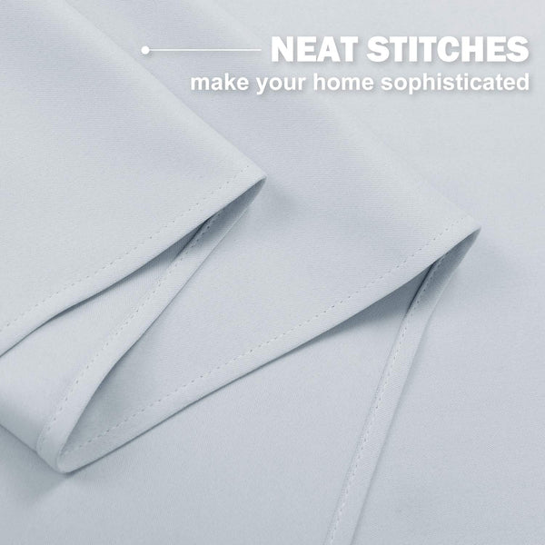 Pale grey curtain fabric with neat, even stitches along the professionally finished edges.