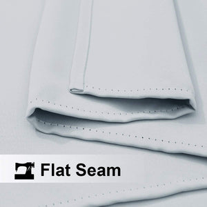 Close-up of light grey woven fabric showing a neat, durable flat seam with visible stitching.