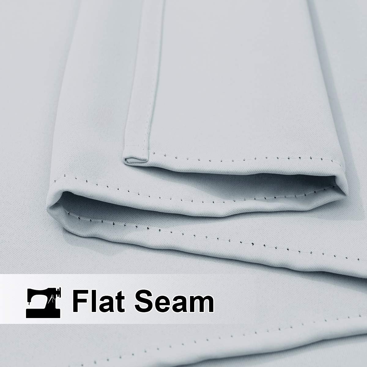 Close-up of light grey fabric showcasing a perfectly sewn flat seam with tiny, even stitches.