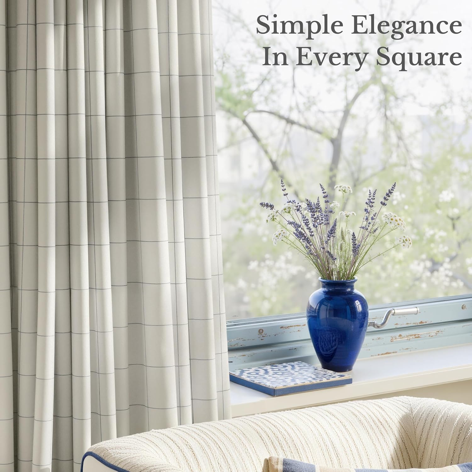 Light grey window curtains with a subtle thin blue grid pattern, neatly pleated, by a bright window.