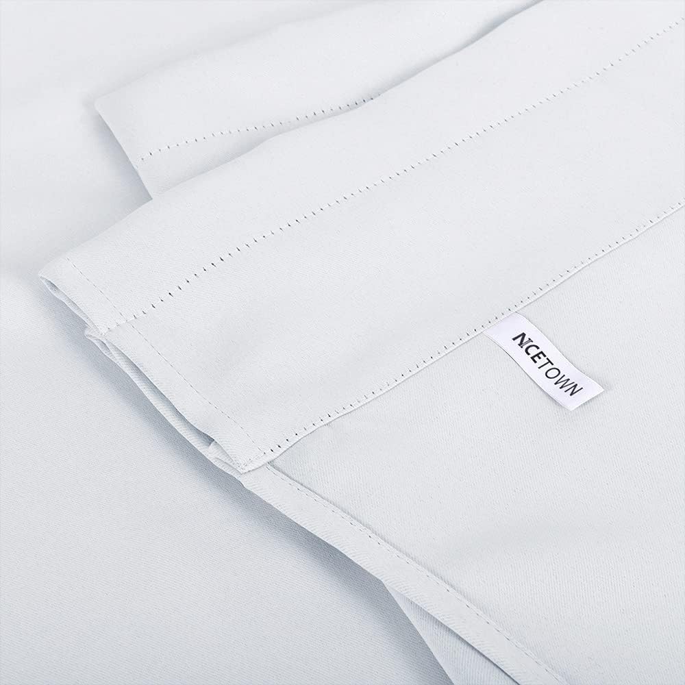 Light grey blackout curtain panel close-up, showing pre-punched holes for grommets and an NCETOWN brand tag.