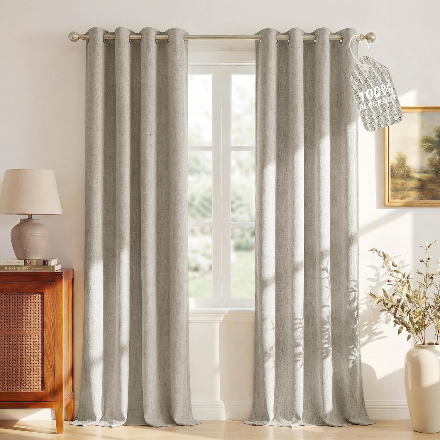 Light grey linen-textured blackout curtains with brushed nickel grommet tops hanging over a window.