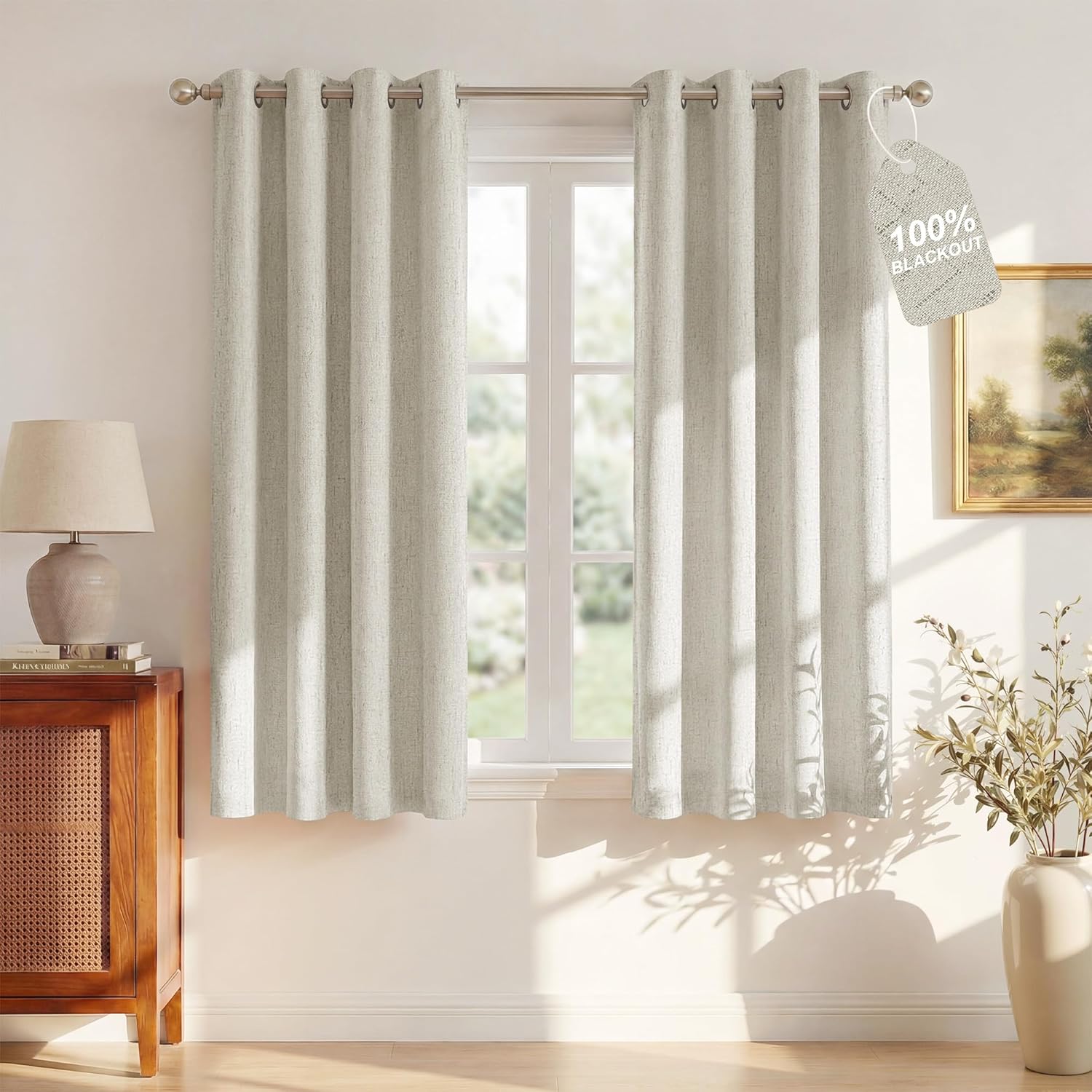 Light grey linen textured 100% blackout curtains with grommet top hanging on a window.