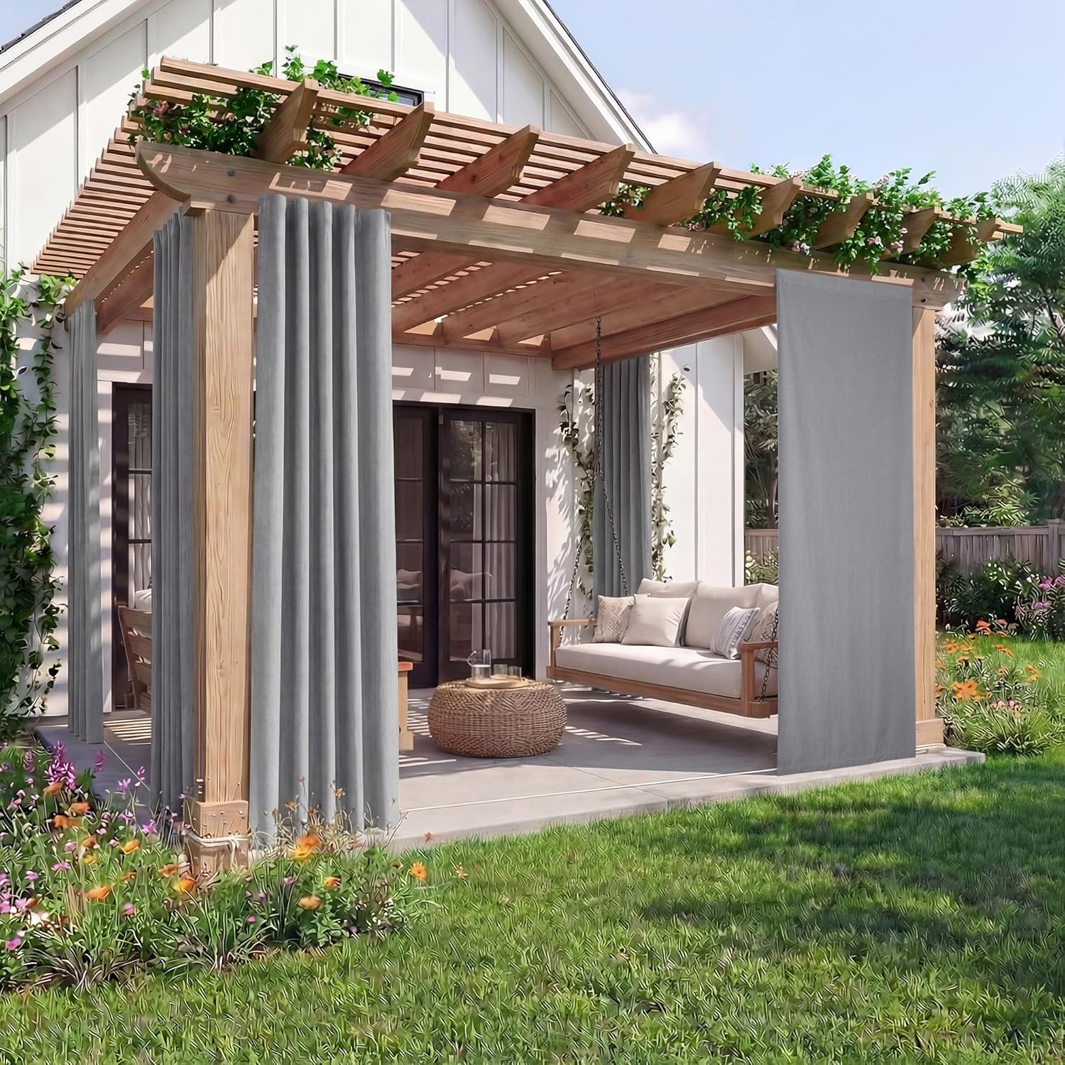 Light grey outdoor curtains hanging from a wooden pergola, providing shade and privacy for a patio swing.