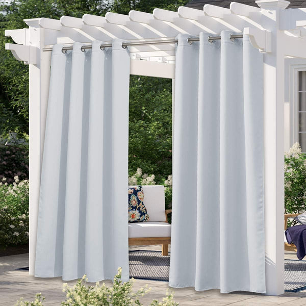 Light grey outdoor curtains with silver grommets on a white pergola, offering shade for a patio.