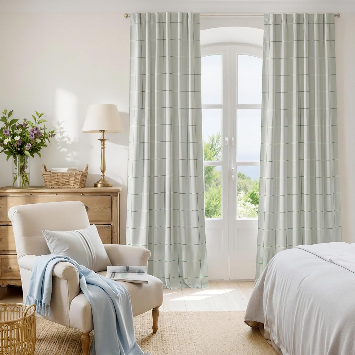 Full length light grey curtains with a subtle plaid grid pattern, hanging in a bright bedroom with an outdoor view.