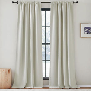 Light grey rod pocket curtains with a smooth, thick fabric, draped over a window frame.