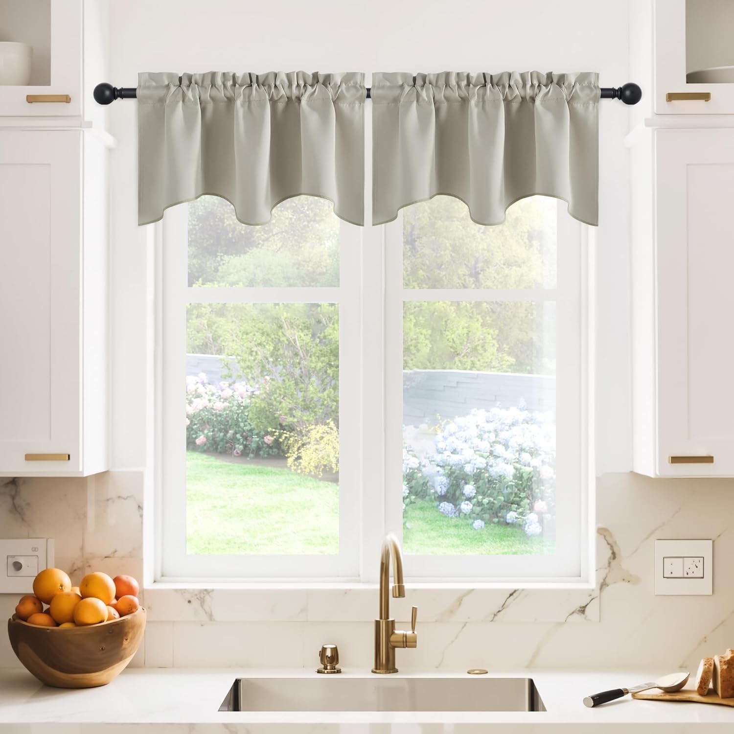 Light grey fabric valance with a scalloped bottom, hung on a black rod over a kitchen window.