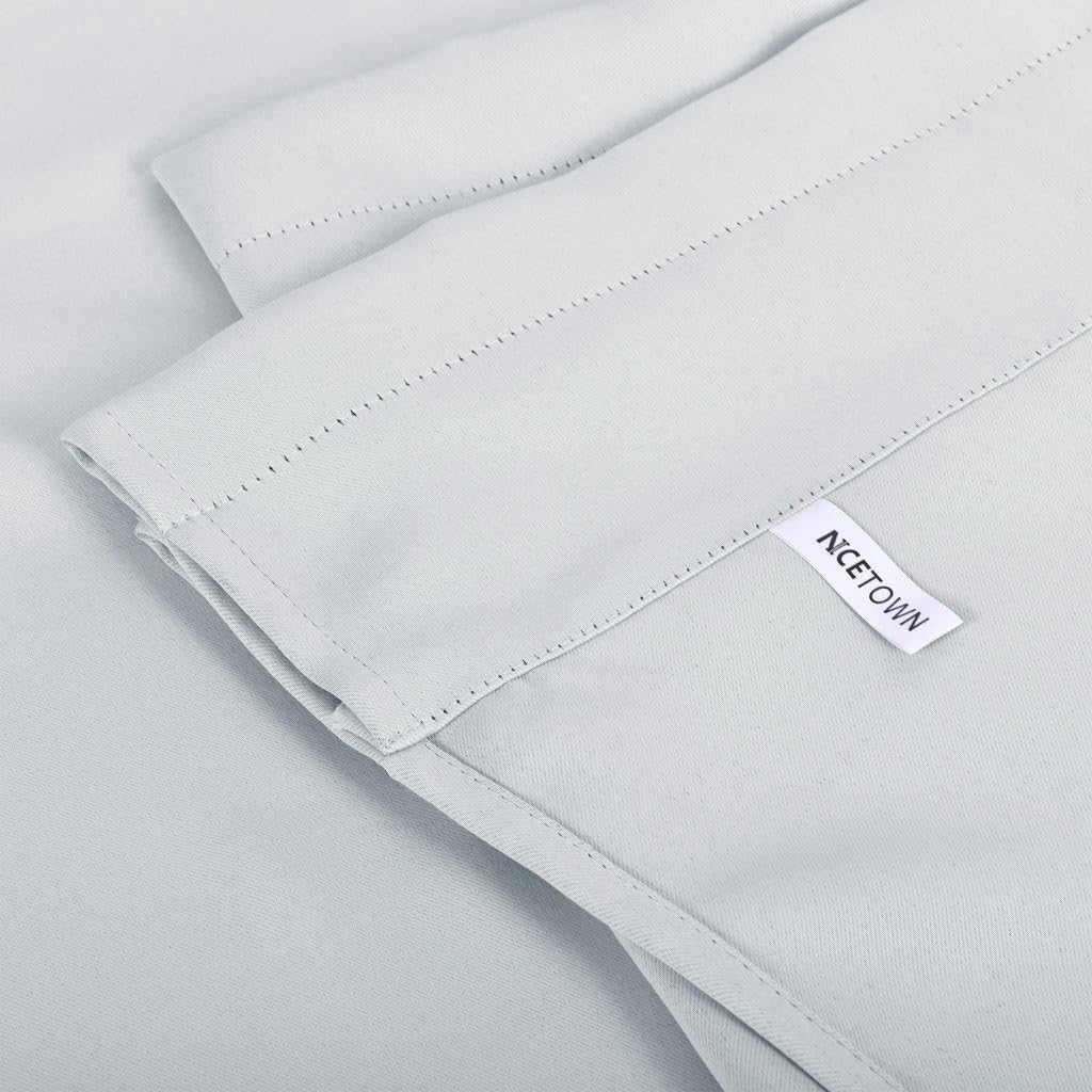 Close-up of a light grey smooth fabric curtain panel with a stitched header. A white 'NCETOWN' brand label is visible.