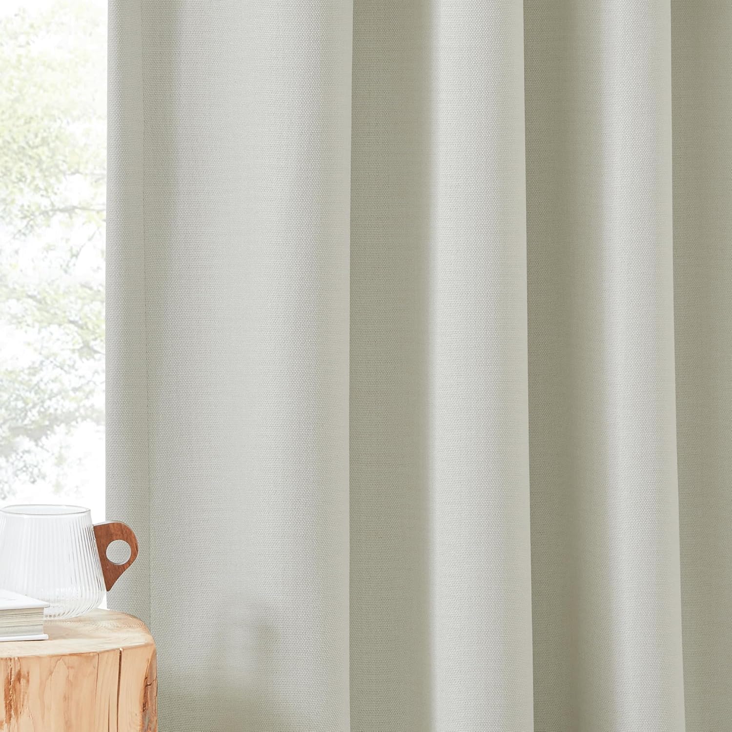 Light grey textured blackout curtains with subtle woven fabric and soft folds.