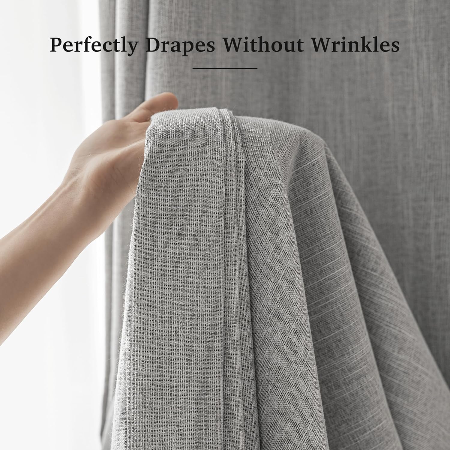 A hand gently holds a light grey textured curtain panel, showcasing its smooth, wrinkle-free drape.