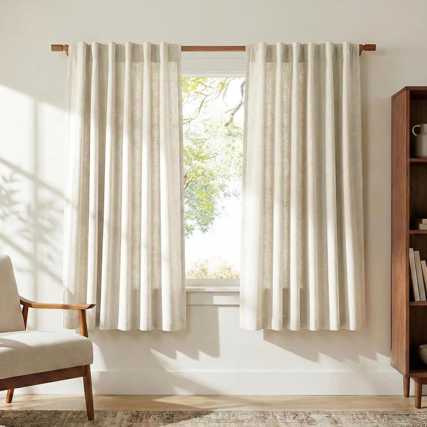 Light beige linen curtains on a wooden rod in a bright, minimalist living room.