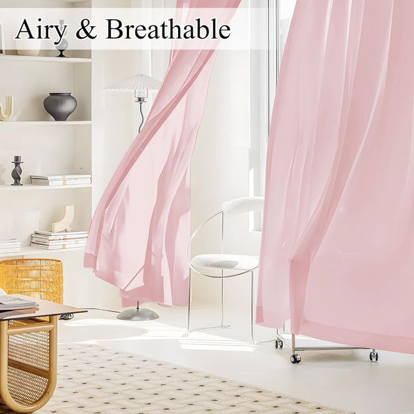 Light pink sheer curtains with an airy texture gently billow by a bright window in a modern room.
