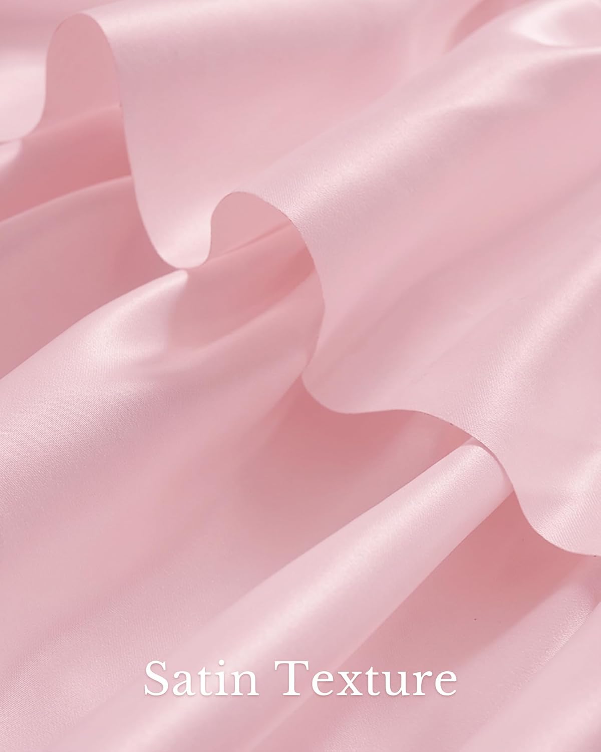 Close-up of soft light pink satin fabric showing elegant folds and a shimmering texture.