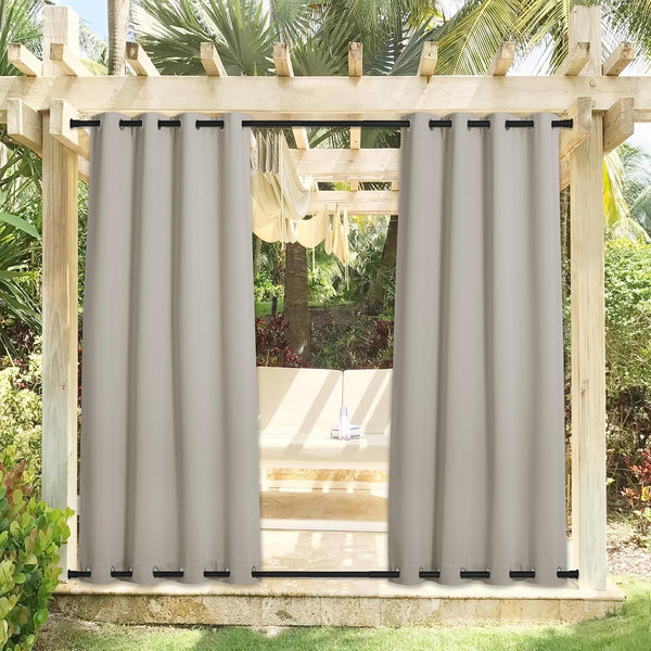 Light taupe outdoor patio curtains with black grommet tops and bottoms, hanging on wooden pergola.