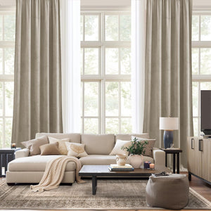 Light taupe textured linen drapes with natural folds hanging over a large window in a modern living room.
