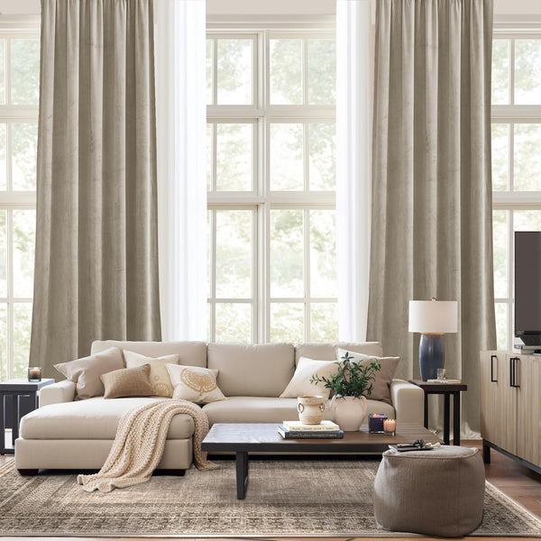 Light taupe textured linen drapes with natural folds hanging over a large window in a modern living room.