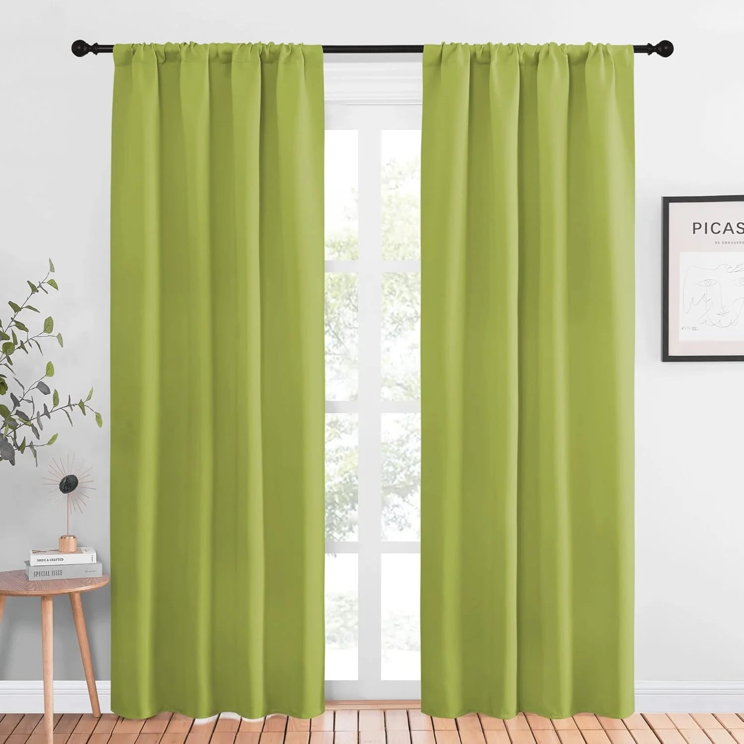Lime green rod pocket curtains hanging on a black curtain rod in a bright modern room