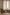 Two natural linen-blend tab top curtains provide soft light filtering over a window on a wooden rod.
