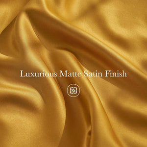 Draped luxurious deep gold matte satin fabric with soft folds and a smooth, non-shiny finish.