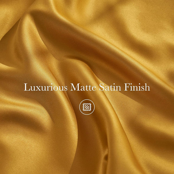 Draped luxurious deep gold matte satin fabric with soft folds and a smooth, non-shiny finish.