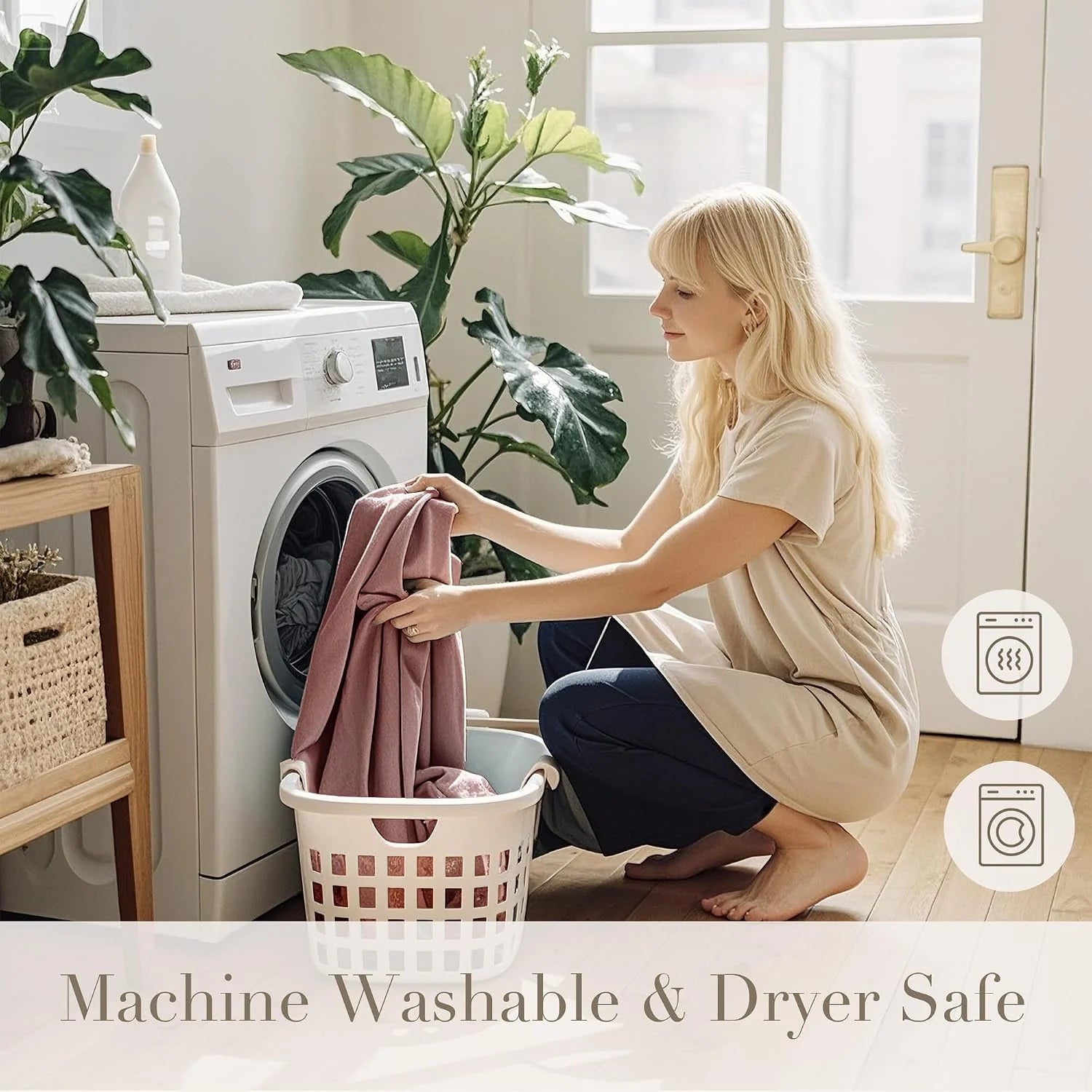 Woman loading soft pink fabric into a front-load washer in a bright laundry room