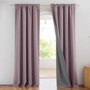 Mauve textured blackout curtains with a dark grey liner on a wooden rod next to an arched window.