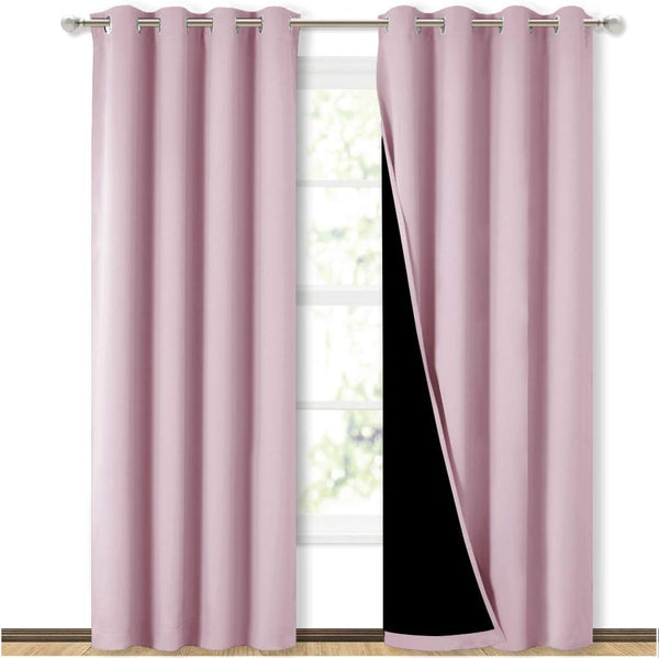 Pair of mauve pink blackout curtains with silver grommet tops, one revealing dark lining.