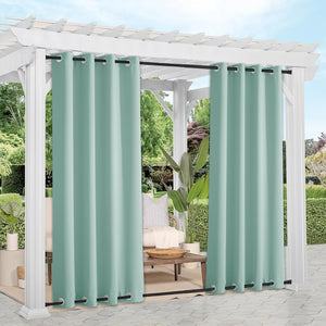 Mint green outdoor privacy curtains with black grommet tops hanging from a white pergola over a patio seating area.