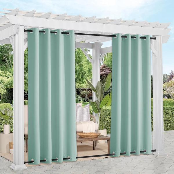 Mint green outdoor privacy curtains with black grommet tops hanging from a white pergola over a patio seating area.