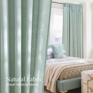 Soft mint green natural fabric pleated curtains hang by a bright window in a modern bedroom.
