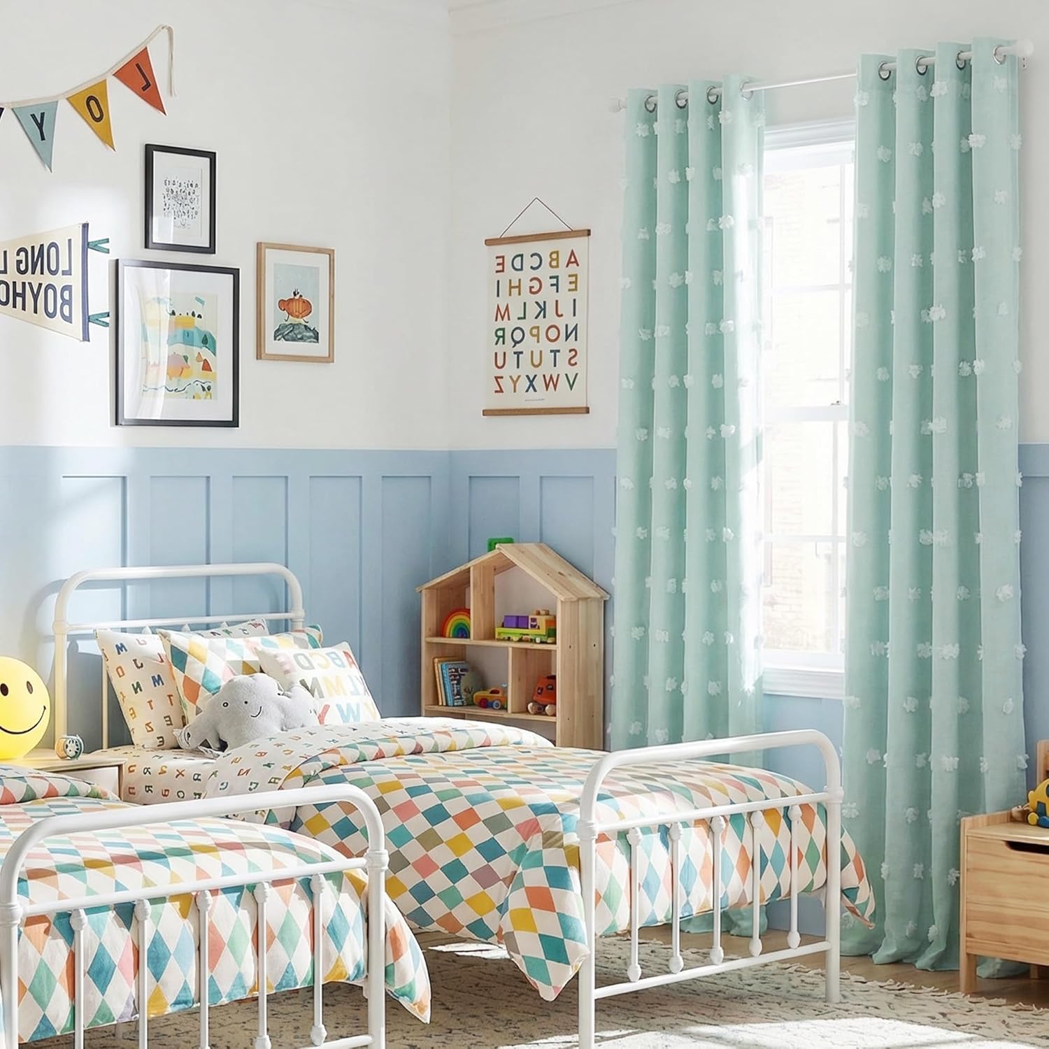 Mint green curtains with white pom-pom dots and grommet tops hanging in a bright kids' bedroom.