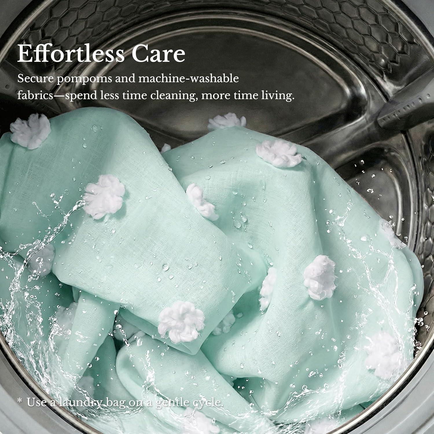 Mint green linen fabric with white pompom tufts washing in a stainless steel machine.