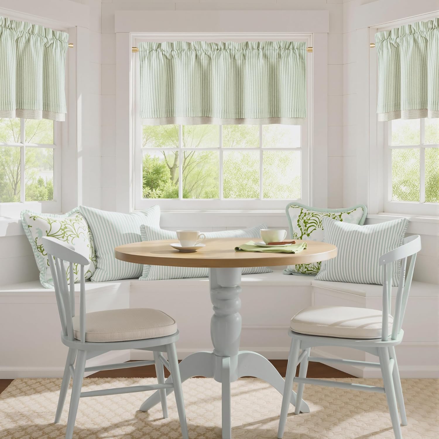 Light mint green striped gathered valances with natural trim adorn a bright window.