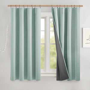 Textured mint green blackout curtains with dark gray lining, one panel revealing the light-blocking fabric.