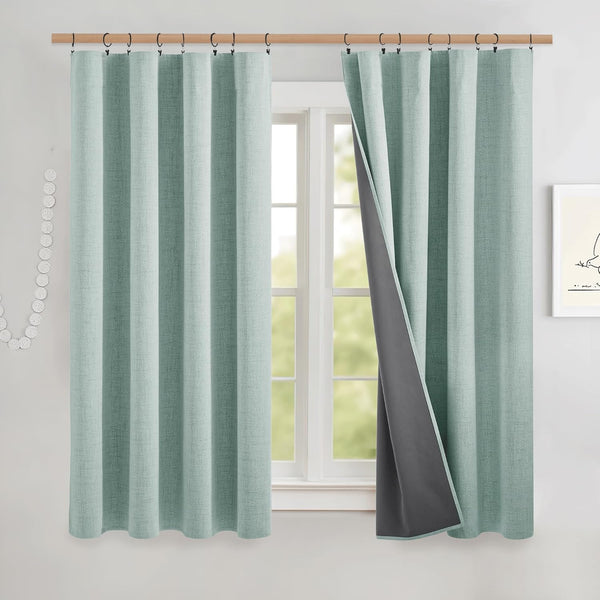 Textured mint green blackout curtains with dark gray lining, one panel revealing the light-blocking fabric.
