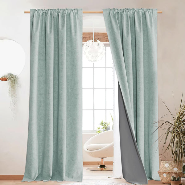 Textured mint green blackout curtains with dark gray lining, hanging with a gathered rod pocket top.