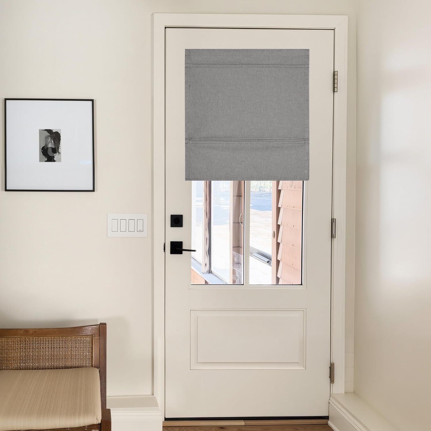Modern gray fabric roman shade with flat folds on a white door window, offering privacy and light filtering.