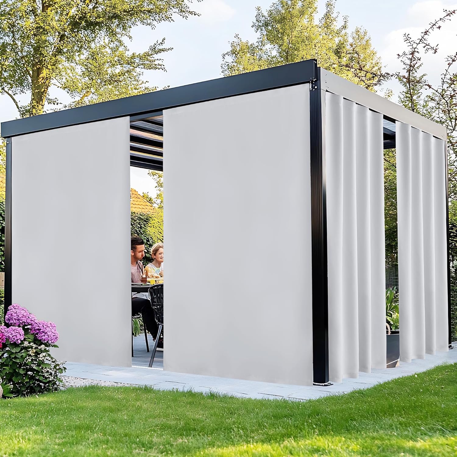 Light grey side privacy curtains on a modern black-framed pergola in a green garden setting.